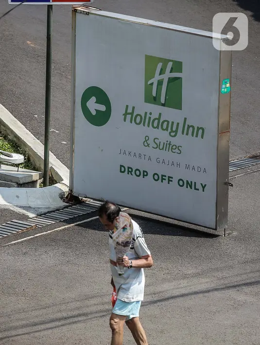 Seorang pria berjalan di sekitar Hotel Holiday Inn, Gajah Mada, Jakarta, Minggu (25/4/2021). Satgas Penanganan COVID-19 menyiapkan Hotel Holiday Inn sebagai tempat karantina bagi 141 WNA khususnya asal India yang negatif COVID-19 untuk dipantau 14 hari ke depan. (Liputan6.com/Faizal Fanani)