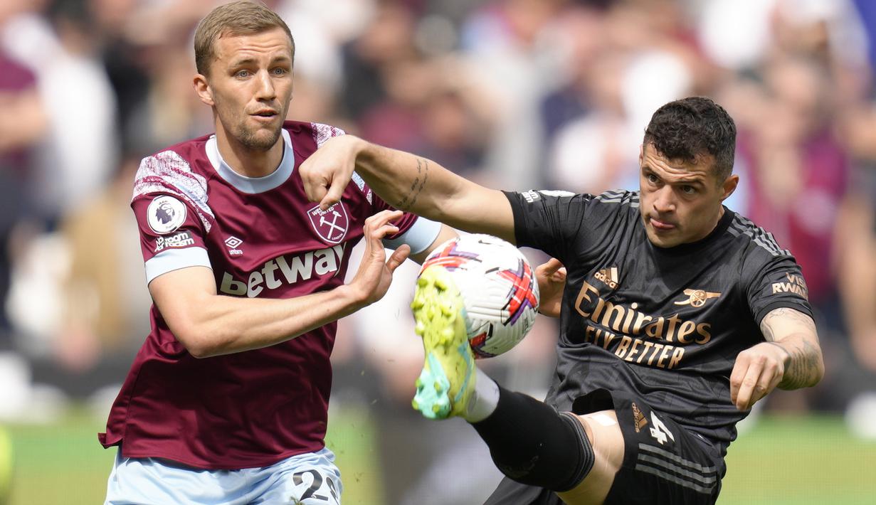 Gelandang Arsenal, Granit Xhaka (kanan) berebut bola dengan gelandang West Ham United, Tomas Soucek pada laga pekan ke-31 Liga Inggris 2022/2023 di London Stadium, London (17/4/2023). (AP Photo/Kirsty Wigglesworth)
