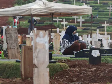 Warga melayat di area pemakaman jenazah COVID-19 di TPU Pondok Ranggon, Jakarta, Rabu (2/12/2020). TPU Pondok Ranggon  hanya melayani jenazah COVID-19 muslim dengan sistem tumpang. (Liputan6.com/Herman Zakharia)