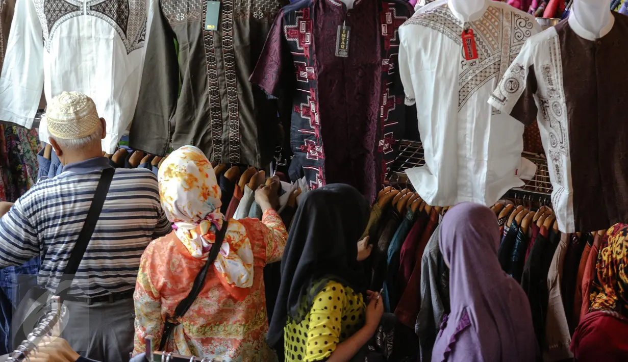 Pengunjung melihat-lihat pakaian yang akan dibelinya di pusat perbelanjaan Blok B Pasar Tanah Abang, Jakarta, Minggu (28/6). Pusat perbelanjaan di Ibukota mulai dipadati warga yang ingin membeli kebutuhan Lebaran. (Liputan6.com/Faizal Fanani)