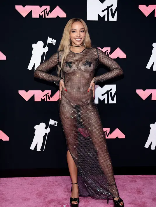 Tinashe melengkapi gaun shift hitamnya yang benar-benar tipis dan berkilau dengan sepasang tanda X hitam yang ditempel di bagian tubuh sensitifnya.  [@mtv]