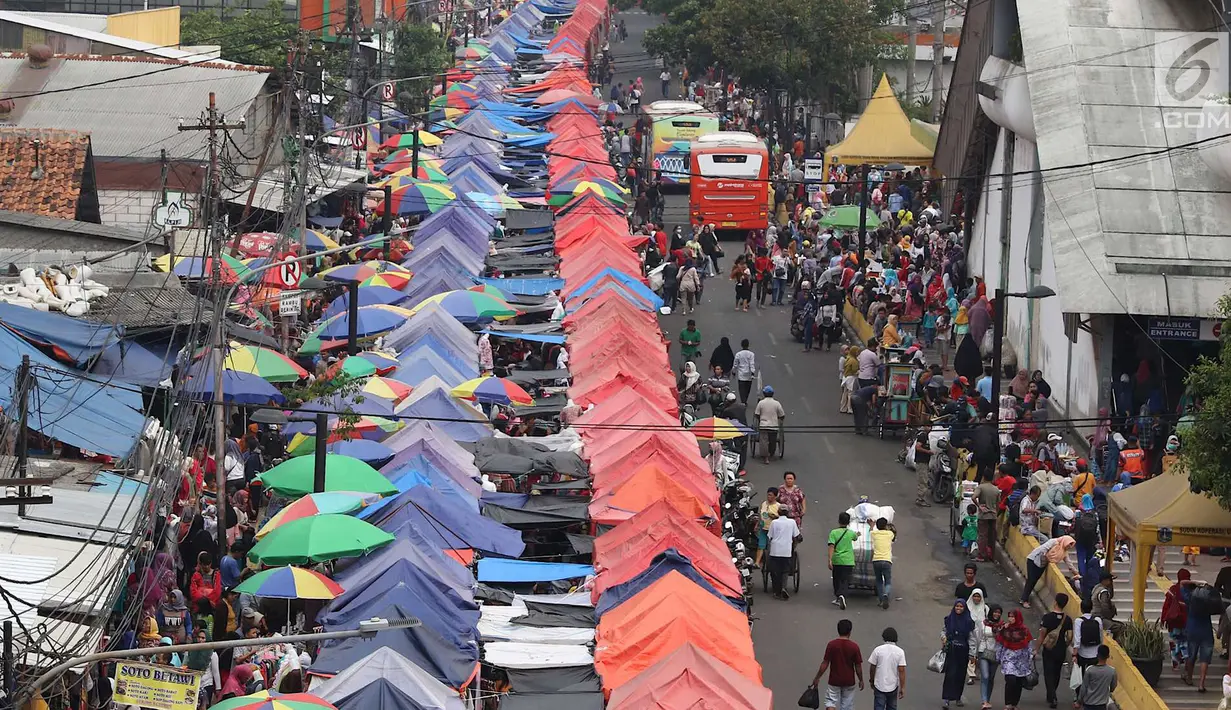 Suasana aktivitas jual beli pedagang kaki lima (PKL) di depan Stasiun Tanah Abang, Jakarta, Kamis (3/5). Diberikannya izin berjualan di kawasan tersebut menyebabkan fungsi trotoar dan jalan raya beralih fungsi. (Liputan6.com/Immanuel Antonius)