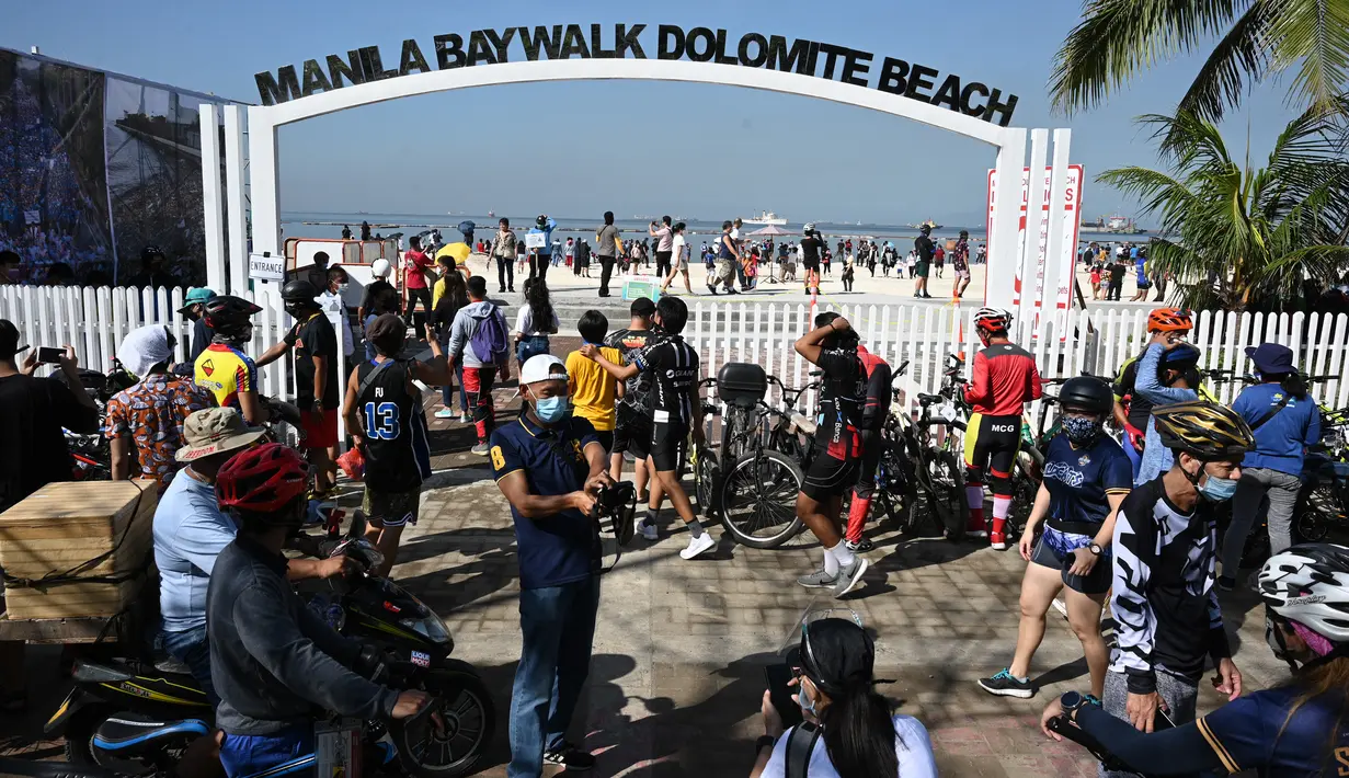 Pemandangan orang-orang yang berkumpul di Manila baywalk dolomite beach di sepanjang boulevard Roxas, kota Manila, Filipina pada Minggu (17/10/2021). Sehari sebelumnya, pihak berwenang melonggarkan pembatasan karantina di ibu kota negara itu. (Ted ALJIBE / AFP)