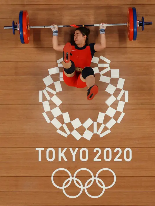 Foto yang diambil dengan kamera robot menunjukkan atlet Vietnam Hoang Thi Duyen terjatuh saat bertanding angkat besi 59kg putri Olimpiade Tokyo 2020 di Tokyo International Forum di Tokyo pada 27 Juli 2021. (Chris GRAYTHEN / POOL / AFP)