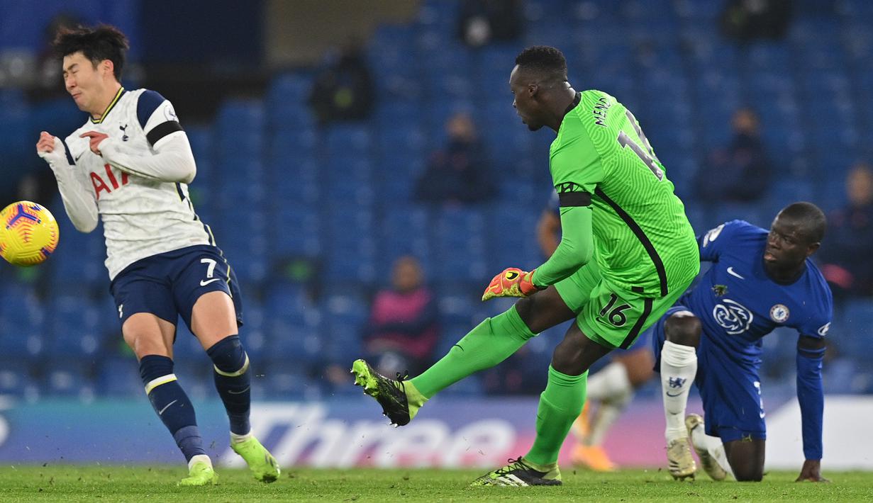 Kiper Chelsea, Edouard Mendy, membuang bola dari ancaman striker Tottenham Hotspurs, Son Heung-Min (kiri) dalam laga lanjutan Liga Inggris 2020/21 di Stamford Bridge, Minggu (29/11/2020) waktu setempat. Chelsea bermain imbang 1-1 dengan Tottenham. (AFP/Matthew Childs/Pool)