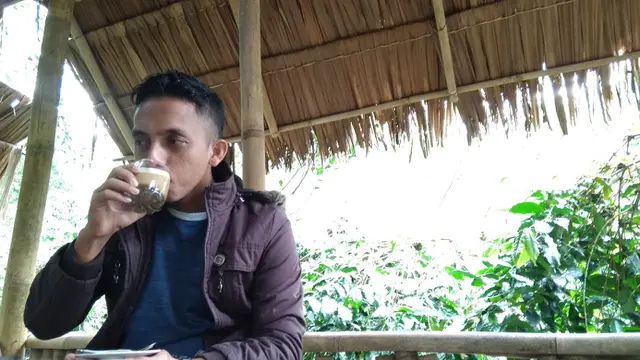 Seorang pengunjung sedang mencicipi kopi di kafe Seladang, Kecamatan Wih Pesam, Kabupaten Bener Meriah, Provinsi Aceh (Liputan6.com/Rino Abonita)