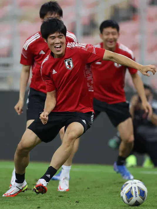 Bek Jepang, Takehiro Tomiyasu membawa bola selama sesi latihan di Stadion King Abdullah Sport City di Jeddah (6/10/2021). Jepang akan bertanding melawan Arab Saudi pada grup B Kualifikasi Dunia Qatar 2022 di Stadion King Abdullah Sports City. (AFP Photo)