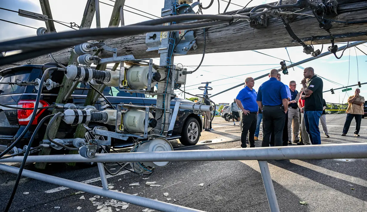 Sejumlah tiang listrik tampak bertumbangan akibat hantaman badai tersebut. Beberapa kendaraan rusak akibat tertimpa tiang listrik yang tumbang. (Jerry Jackson/The Baltimore Sun via AP)