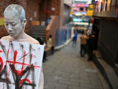Seorang seniman tampil untuk memberikan penghormatan di sebuah gang di kawasan hiburan malam Itaewon yang populer di Seoul pada tanggal 29 Oktober 2024. (Shin Yong-ju/AFP)