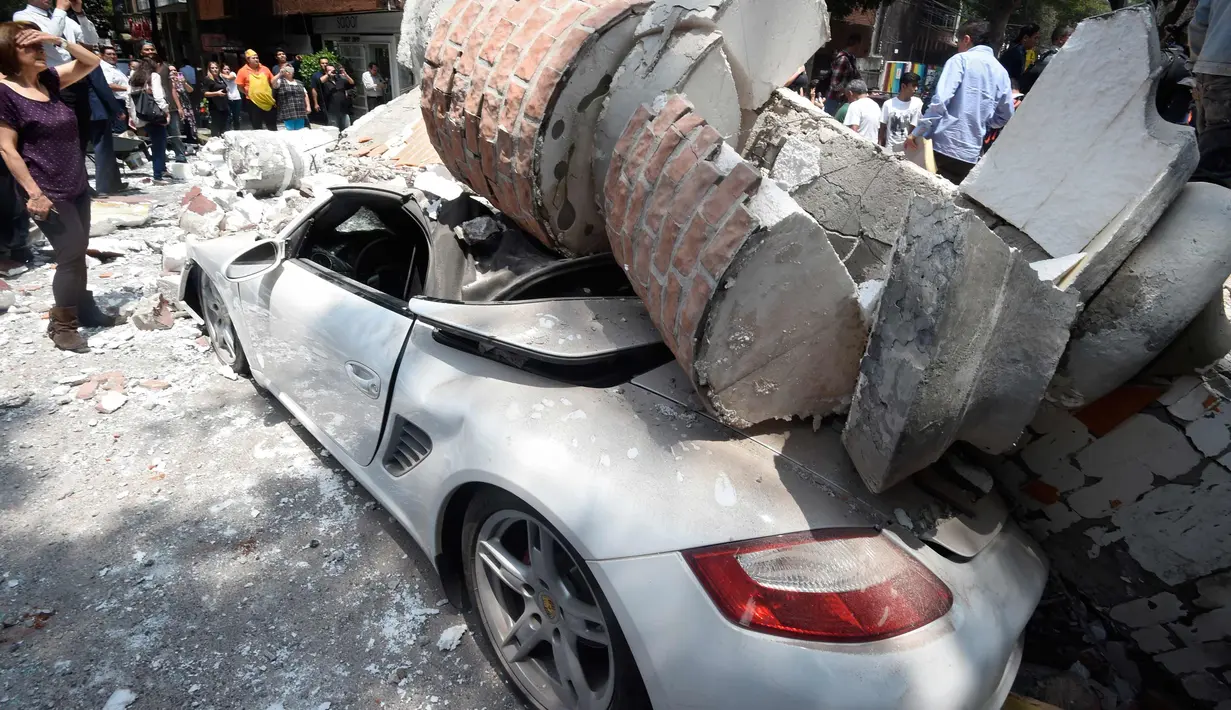 Bangunan yang menghantam sebuah mobil setelah gempa mengguncang Kota Meksiko (19/9). Sekitar 100 orang tewas dalam bencana gempa bumi 7,1 Skala Richter tersebut. (AFP Photo/Alfredo Estrella)