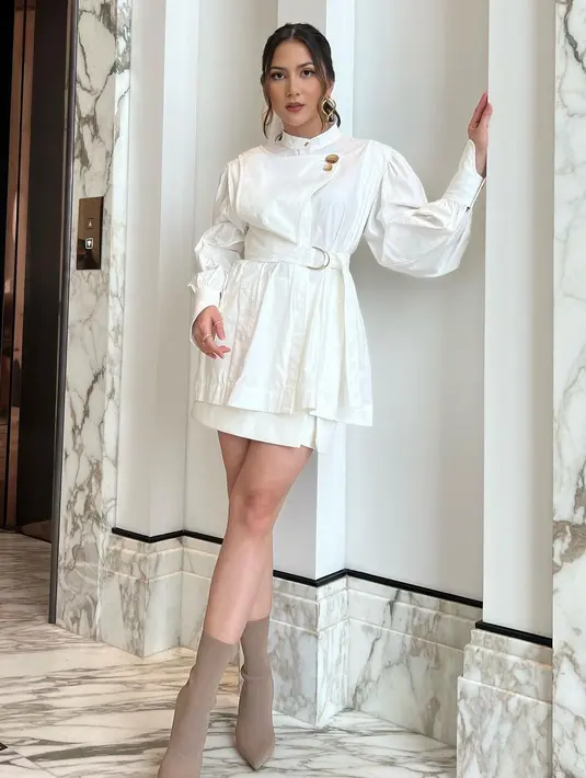 Satu lagi inspirasi mengenakan outfit serba putih ala Jessica Mila. Atasan lengan panjang yang simpel, dipadu dengan mini skirt yang sama-sama berwarna putih, lalu dipadu dengan midi heels boots berwarna cokelat muda yang lembut. Foto: Instagram.