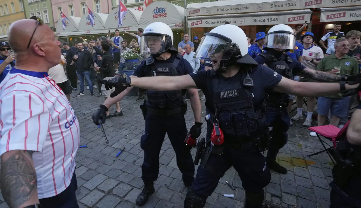 Para polisi berusaha meredakan kericuhan antar fans menjelang laga final Conference League 2024/2025 antara Real Betis melawan Chelsea di sekitar restoran kota Wroclaw, Polandia, Selasa (27/05/2025) waktu setempat. (AP Photo/Czarek Sokolowski)