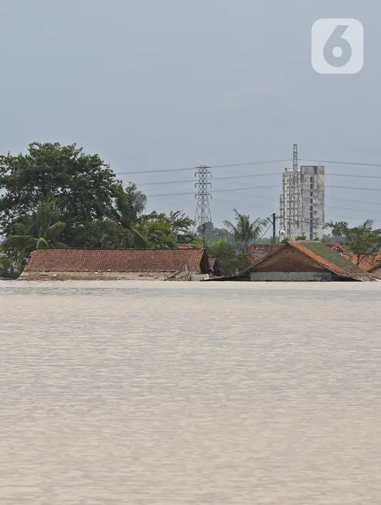 Kondisi banjir yang merendam hingga mencapai atap rumah warga di Desa Karangligar, Kecamatan Telukjambe Barat, Karawang, Jawa Barat, Kamis (10/2/2021). Banjir akibat meluapnya sungai Citarum dan Cibeet itu membuat ratusan rumah terendam banjir dan ratusan hektar sawah. (Liputan6.com/Herman Zakharia)
