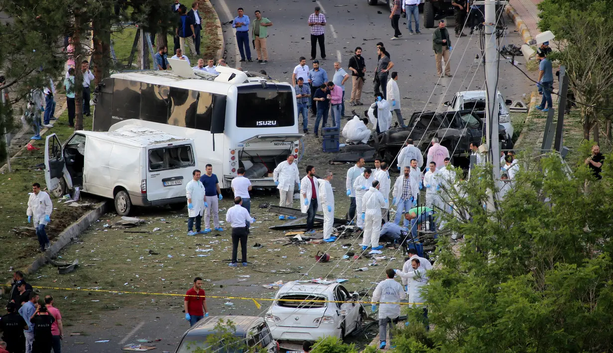 Petugas ahli forensik melakukan olah TKP di lokasi ledakan sebuah bom mobil di kota Diyarbakir, Turki, Selasa (10/5). Ledakan menghantam kendaraan lapis baja polisi, setidaknya ada tiga korban tewas dan puluhan mengalami luka-luka. (REUTERS/Sertac Kayar)