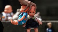 Seseorang meletakkan boneka mainan di halaman gedung Kongres Kolombia untuk memprotes kekerasan seksual terhadap anak di Bogota, Selasa (20/11). Protes ini untuk meningkatkan kesadaran tentang tanggung jawab perlindungan anak-anak. (DANIEL MUNOZ/AFP)