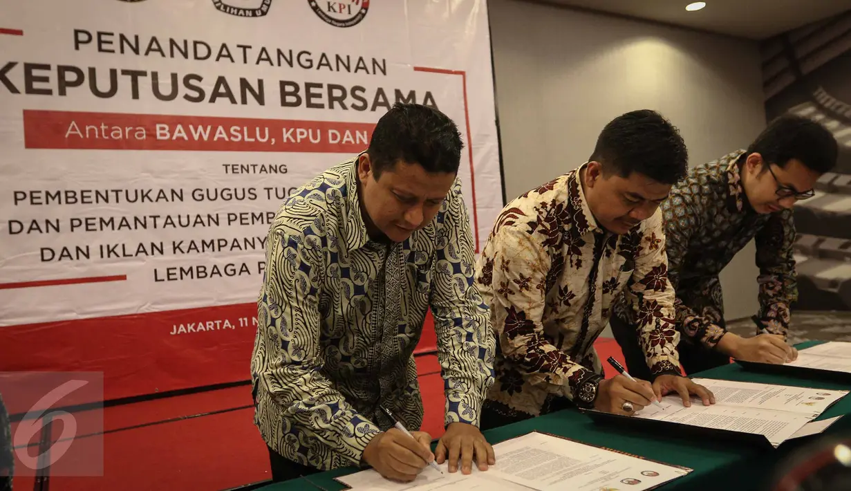(ki-ka) Ketua Bawaslu Muhammad, Ketua KPU Juri Ardiantoro, Ketua KPI Yuliandre Darwis menandatangani Keputusan Bersama Antara Bawaslu, KPU, Dan KPI di Jakarta, Jumat (11/11). (Liputan6.com/Faizal Fanani)