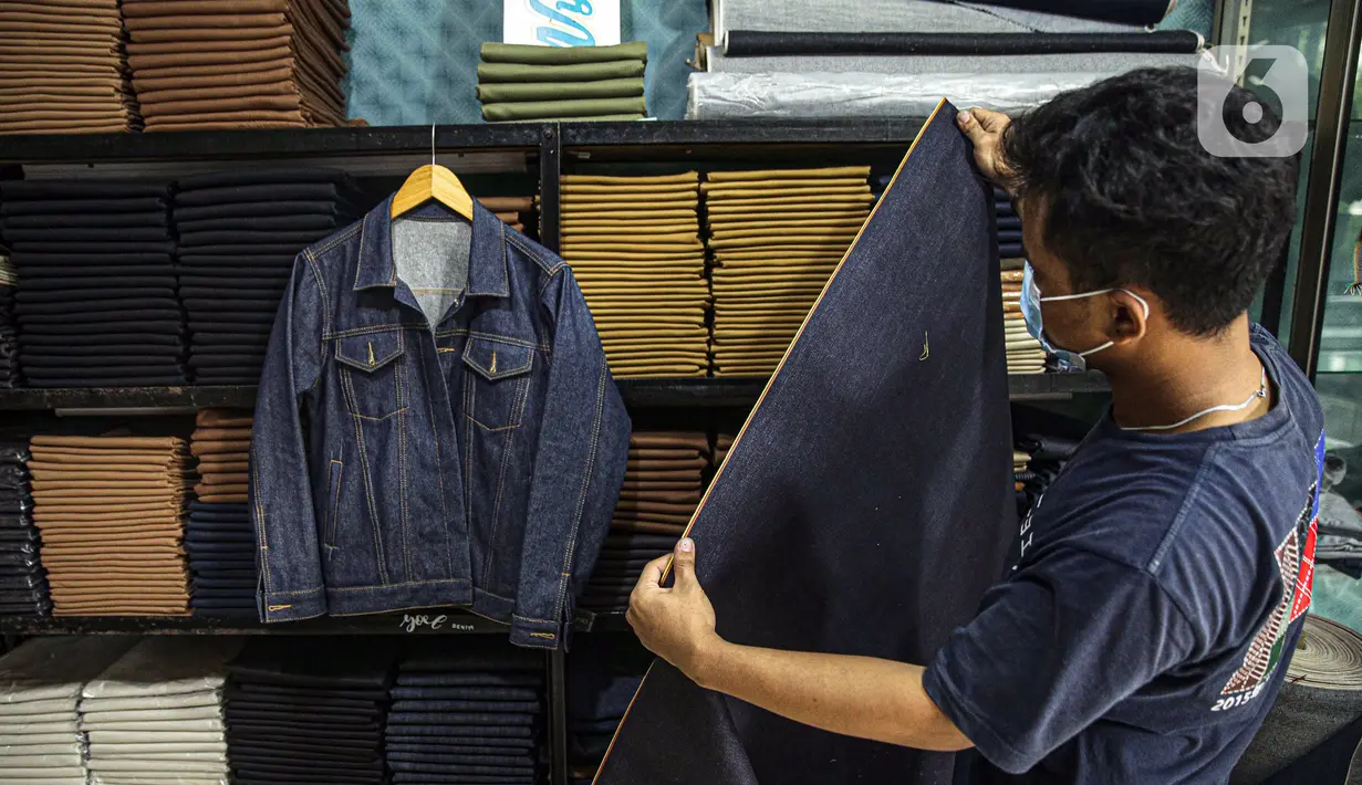 Penjahit memilih bahan yang akan dijahit di Nyoel Jeans co, Jakarta, Jumat (22/10/2021). Harga kapas saat ini mencapai USD 1,16/pon atau sekitar Rp 16.530/pon (asumsi kurs Rp 14.250/USD). (Liputan6.com/Faizal Fanani)