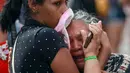 Kerabat dari narapidana menangis di pos pemeriksaan menyusul kerusuhan yang terjadi di dalam penjara kota Amazon, Brasil, Senin (2/1). Beberapa korban yang berasal dari anggota geng narkotik Brasil tewas dengan tubuh terpenggal. (REUTERS/Michael Dantas)