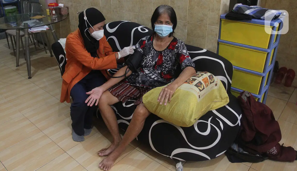 Petugas kesehatan melakukan pemeriksaan kepada lansia saat vaksinasi booster COVID-19 dari rumah ke rumah di Poris Plawad, Tangerang, Jumat (21/1/2022). Pelaksanaan vaksinasi dari rumah ke rumah untuk memudahkan para lansia mendapatkan vaksin booster COVID-19. (merdeka.com/Arie Basuki)