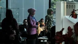 Istri Bupati Bogor, Eli Halimah (berbaju ungu, tengah) berada di lobi gedung KPK, Jakarta, Jumat (9/5/2014) (Liputan6.com/Johan Tallo)