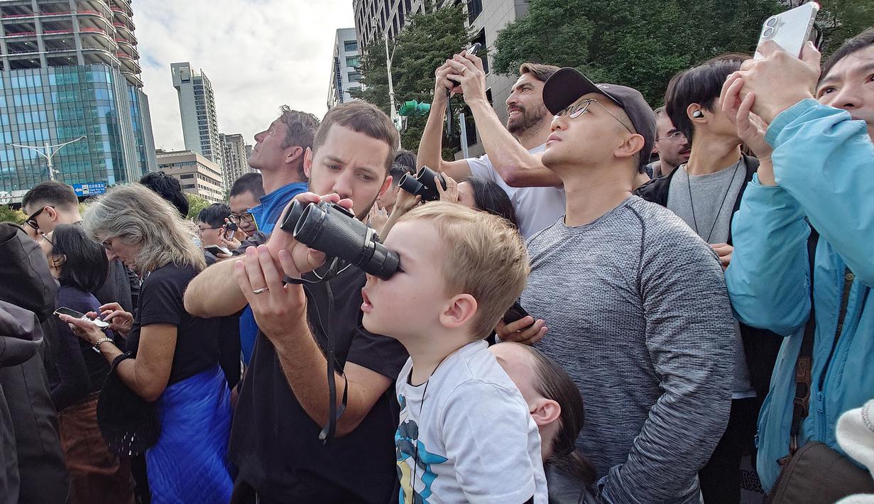 Masyarakat melihat aksi atlet panjat tebing 'free solo' asal Amerika, Alex Honnold saat memanjat gedung Taipei 101 tanpa tali pengaman di Taipei, Minggu (25/01/2026). (AP Photo/Chiang Ying-ying)