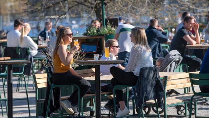 Orang-orang menikmati cuaca hangat di Stockholm, Rabu (22/4/2020). Swedia belum memberlakukan lockdown, seperti mayoritas negara Eropa lainnya, namum pemerintah memberikan tanggung jawab besar kepada penduduknya untuk membantu mengurangi penyebaran virus corona. (Anders WIKLUND/TT NEWS AGENCY/AFP)