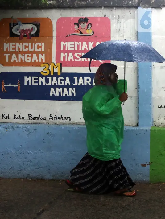 Warga melintas di depan mural yang berisi pesan 3M di Jakarta, Rabu (11/11/2020). Mural tersebut dibuat untuk mengingatkan masyarakat agar menerapkan protokol kesehatan saat beraktivitas sehari-hari. (Liputan6.com/Herman Zakharia)