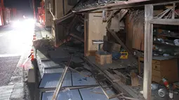 Sebuah rumah runtuh akibat gempa bumi di Koorimachi, prefektur Fukushima, timur laut Jepang, Minggu (14/2/2021).  Pusat gempa berada di kedalaman 60 kilometer lepas pantai Prefektur Fukushima, pada pukul 23.08 waktu setempat. (Jun HIrata/Kyodo News via AP)