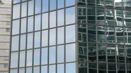 Seorang pria mengambil gambar aksi Alain Robert ketika memanjat gedung di pusat bisnis La Defense, Paris, Prancis, Senin (21/3/2016). Pria yang dijuluki 'Spiderman' ini telah memanjat lebih dari 70 gedung tertinggi di dunia. (Jacques DEMARTHON/AFP)