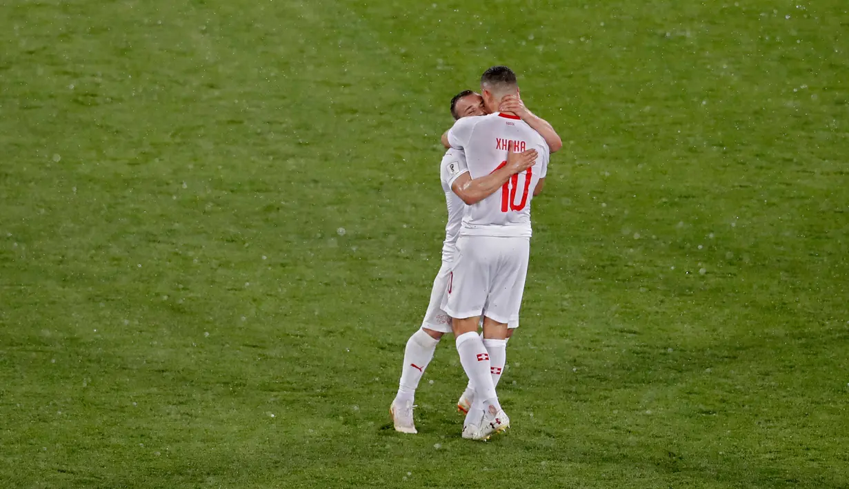 Pemain Swiss,  Xherdan Shaqiri dan Granit Xhaka merayakan kemenangan atas Serbia pada laga grup E Piala Dunia 2018 di Stadion Kaliningrad, Jumat (22/6). Selebrasi Xhaka dan Shaqiri memicu kontroversi ketika mengalahkan Serbia 2-1. (AP/Antonio Calanni)