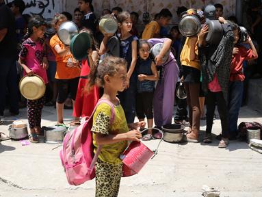 Anak-anak Palestina menunggu di titik distribusi makanan di Nuseirat, Jalur Gaza bagian Tengah, pada 23 Juni 2025. (Eyad BABA/AFP)