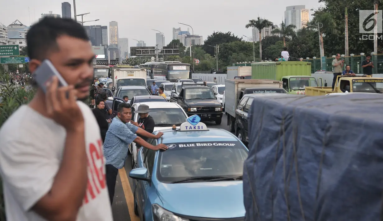 Sejumlah pengendara keluar dari mobil setelah terjebak saat unjuk rasa di Tol Dalam Kota dekat Gedung DPR,  Jakarta, Senin (30/9/2019). Massa diketahui telah memblokade tol di kedua arah, baik dari arah Cawang menuju Tomang, maupun dari arah Tomang menuju Cawang. (merdeka.com/Iqbal S Nugroho)