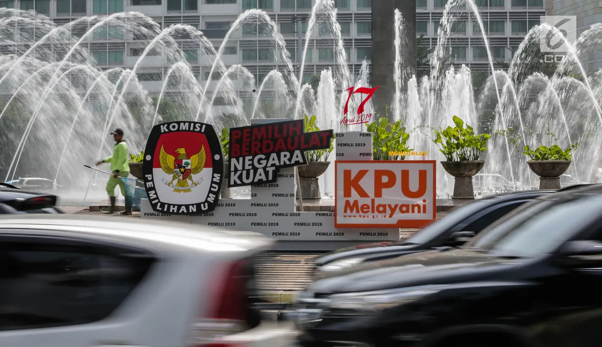 Kendaraan melintas di dekat papan sosialisasi Pemilu 2019 di kawasan Bundaran HI, Jakarta, Rabu (3/4). KPU terus menyosialisasikan kepada masyarakat agar menggunakan hak pilihanya pada Pemilu 2019. (Liputan6.com/Faizal Fanani)