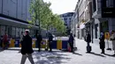 Pelanggan antre memasuki toko pakaian pada hari pembukaannya kembali setelah pelonggaran lockdown di Brussel, Senin (11/5/2020). Warga Belgia rela menghabiskan waktu selama berjam-jam sebelum toko dibuka untuk berbelanja pertama kalinya sejak lockdown pada Maret lalu (Kenzo TRIBOUILLARD/AFP)