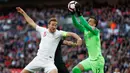 Striker Inggris, Harry Kane, berebut bola dengan kiper Kroasia, Lovre Kalinic, pada laga UEFA Nations League di Stadion Wembley, London, Minggu (18/11). Inggris menang 2-1 atas Kroasia. (AFP/Adrian Dennis)