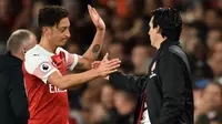 Mesut Ozil bersama Unai Emery. (AFP/Glyn Kirk)