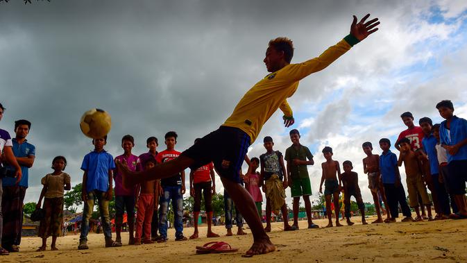 Seorang penggemar Neymar, Mohammad Jahangir Alam menunjukkan keterampilan sepak bolanya di kamp pengungsi Kutupalong di Ukhia, Bangladesh, 19 Juli 2018. Jahangir Alam mencukur rambut dan mewarnainya dengan gaya pemain bola Brasil itu. (AFP/Munir UZ ZAMAN)