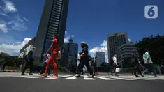 Pejalan kaki melintasi pelican crossing di Jakarta 1/12/2020). Kota Jakarta dengan langit biru menambah keindahan hutan beton. BMKG bahwa kualitas udara Jakarta jadi baik dalam dua minggu ini, Jakarta mengalami hujan dengan intensitas tinggi disertai angin kencang. (merdeka.com/Imam Buhori)