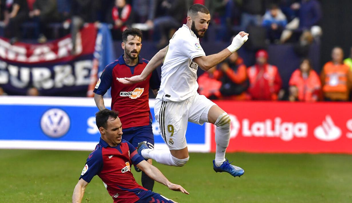 Striker Real Madrid, Karim Benzema, berusaha melewati pemain Osasuna pada laga La Liga di Stadion El Sadar, Minggu (9/2/2020). Real Madrid menang 4-1 atas Osasuna. (AP/Alvaro Barrientos)
