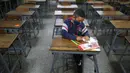 Sebastian (7) mengikuti kelas matematika sendirian pada hari pertama kembali ke sekolah tatap muka sejak dimulainya pembatasan pandemi COVID-19 di Sekolah Andres Bello, Caracas, Venezuela, 25 Oktober 2021. (AP Photo/Ariana Cubillos)