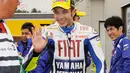 Juara dunia Italia Valentino Rossi melambaikan tangan untuk menyapa para penggemarnya saat ia akan memulai sesi latihan untuk MotoGP Jepang Grand Prix di sirkuit Twin Ring Motegi di Motegi pada 24 April 2009. (AFP/Bintang.com)