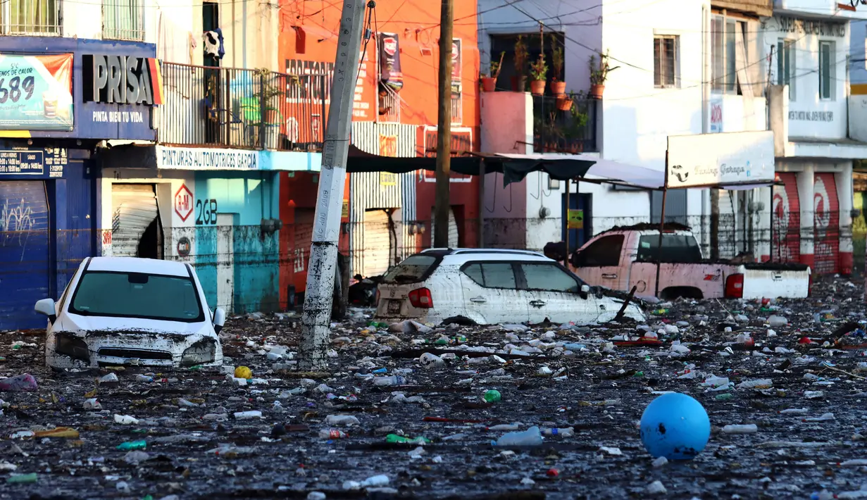 Sejumlah mobil terendam di jalan berlumpur setelah aliran El Seco meluap akibat hujan lebat di Zapopan, Jalisco State, Meksiko, Senin (26/7/2021). (AFP/Ulises Ruiz)