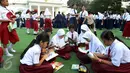 Sejumlah murid sekolah dasar tengah membaca buku di halaman Istana, Jakarta, Rabu (17/8). Sebanyak 500 pelajar menikmati membaca dan mendengarkan dongeng di halaman istana untuk memperingati Hari Buku Nasional. (Liputan6.com/Angga Yuniar)