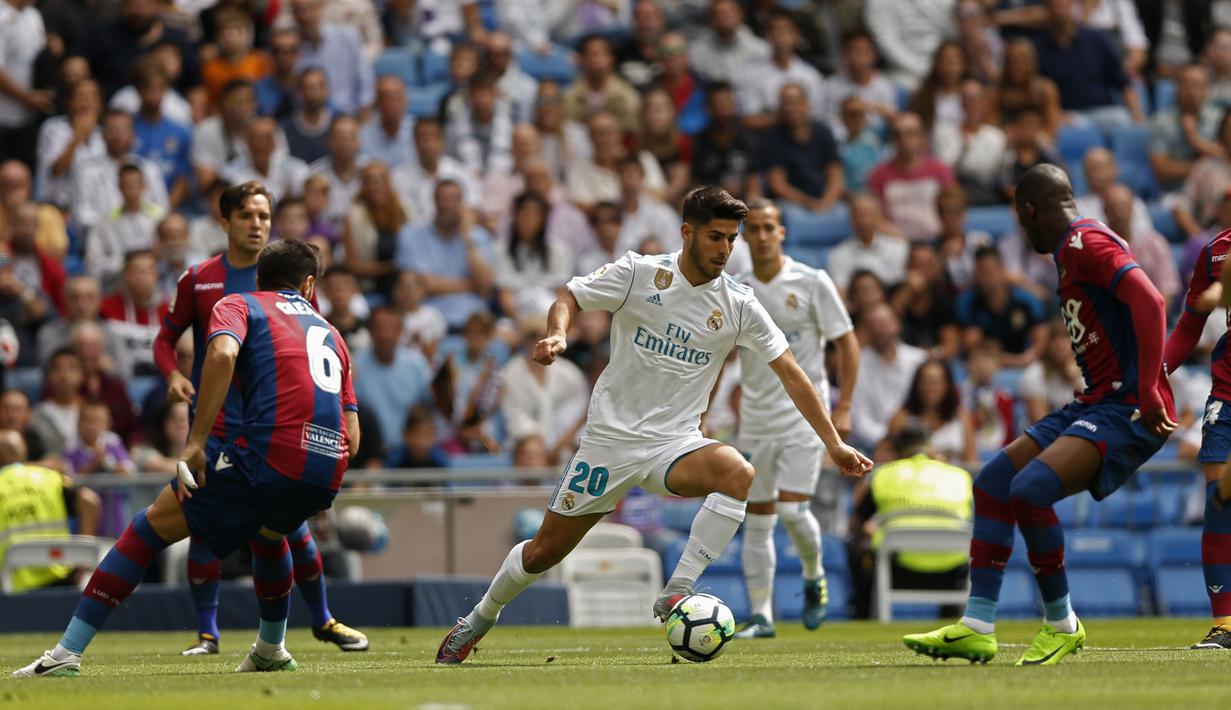 Aksi pemain Real Madrid, Marco Asensio melewati adangan para pemain Levante pada lanjutan La Liga di Santiago Bernabeu stadium, Madrid (9/9/2017). Madrid bermain imbang 1-1. (AP/Francisco Seco)