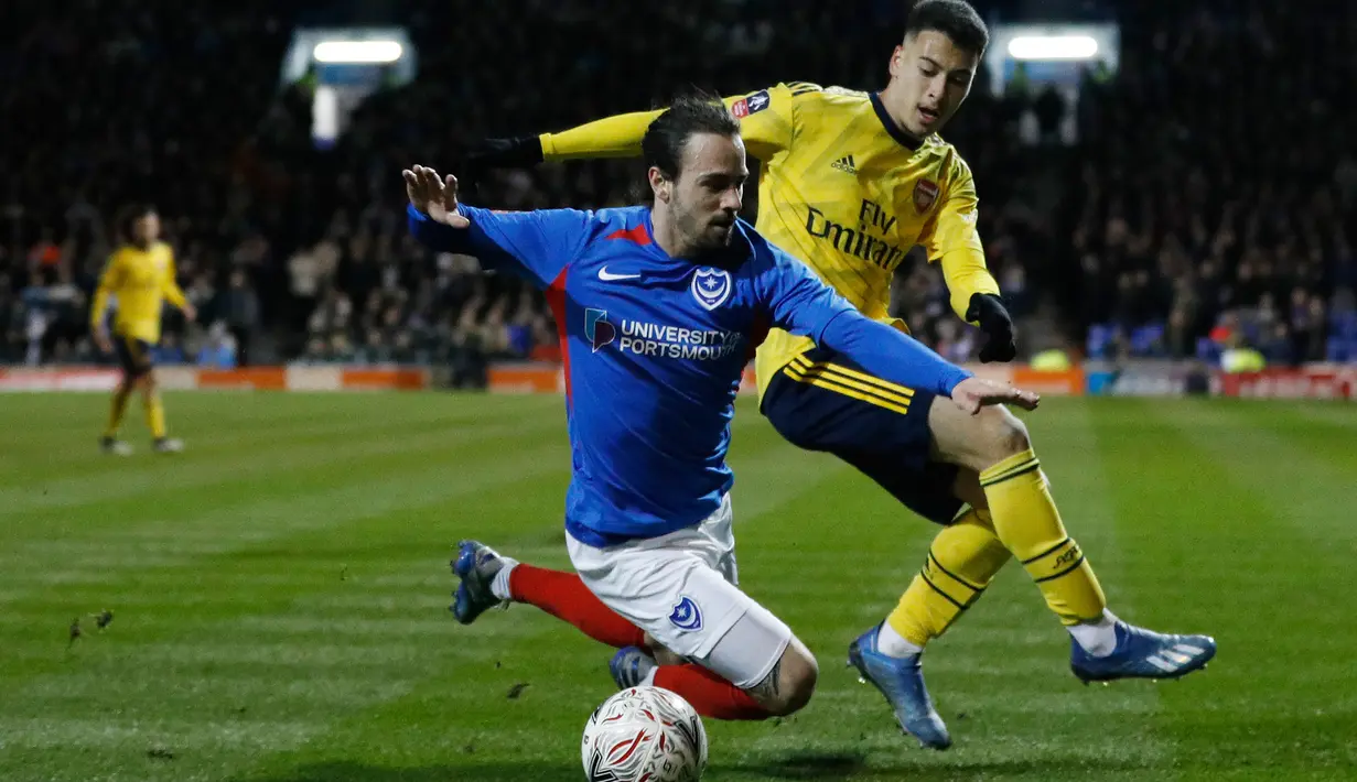 Striker Arsenal, Gabriel Martinelli berebut bola dengan gelandang Portsmouth, Ryan Williams (kiri) pada laga putaran lima Piala FA di Fratton Park, Senin (2/3/2020). Arsenal sukses membungkam tuan rumah Portsmouth dengan skor 2-0. (Adrian DENNIS/AFP)