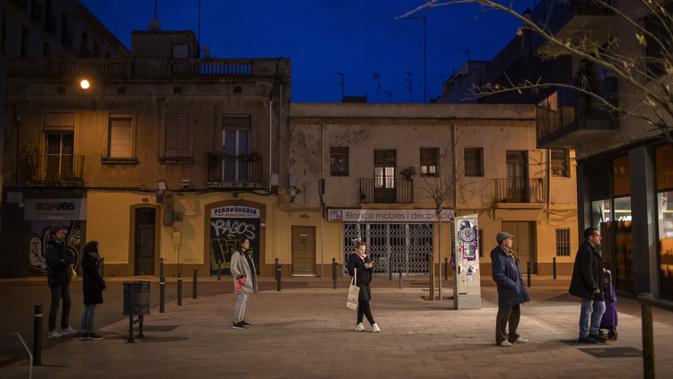 Warga melakukan social distancing atau menjaga jarak saat mengantre untuk memasuki toko di Barcelona, Spanyol, Selasa (17/3/2020). Social distancing adalah cara terbaik untuk mencegah penyebaran virus corona COVID-19. (AP Photo/Emilio Morenatti)
