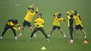 Para pemain Borrusia Dortmund melakukan pemanasan selama sesi latihan di tempat latihan tim di Dortmund, Jerman barat (9/3/2021). Dortmund sebelumnya berhasil mengalahkan Sevilla dengan skor 3-2 di leg pertama. (AFP/Ina Fassbender)