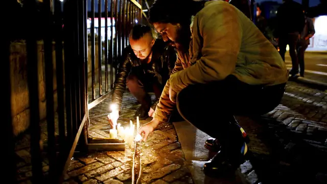 Penggemar Foo Fighters menyalakan lilin di depan hotel tempat mendiang Taylor Hawkins menginap di Bogota.(AP Photo/Leonardo Munoz)