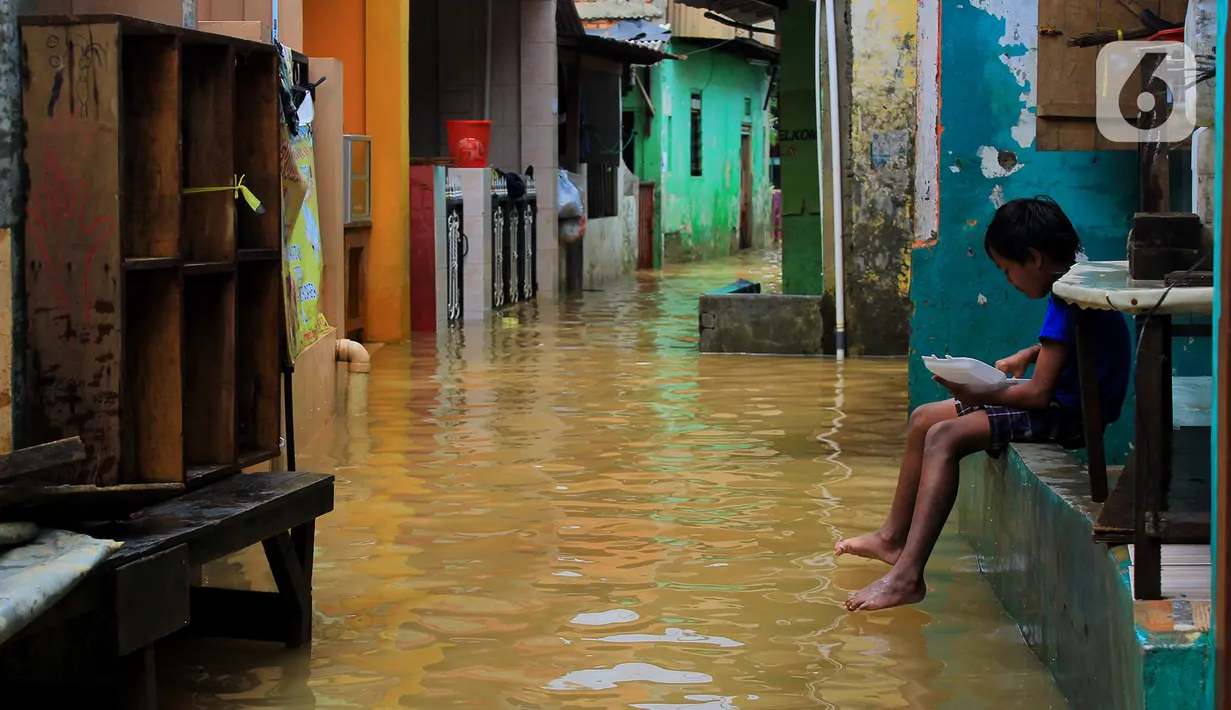 Seorang anak menikmati makanan saat banjir di kawasan Bidara Cina, Kecamatan Jatinegara, Jakarta Timur, Selasa (25/2/2020). Baru satu hari air surut, kawasan Bidara Cina yang bersebelahan dengan Kali Ciliwung kembali mengalami banjir. (merdeka.com/magang/ Muhammad Fayyadh)