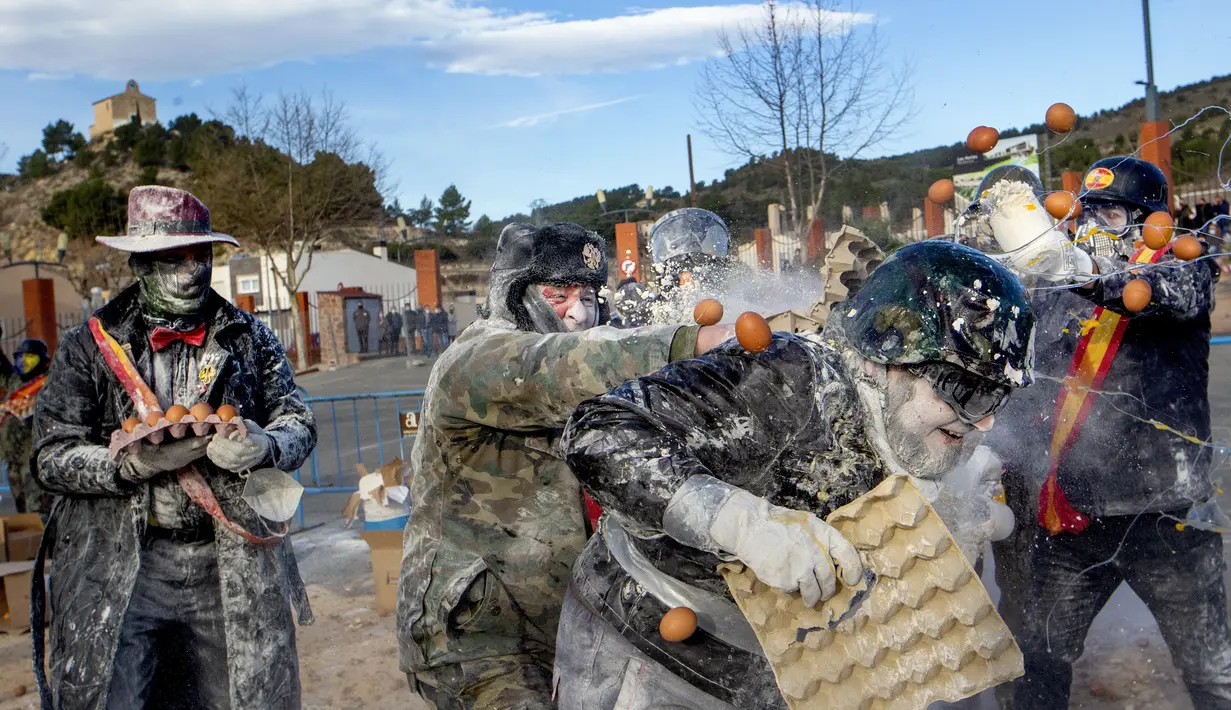 Orang-orang yang bersuka ria saling lempar tepung dan telur dalam festival Els Enfarinats, di kota Ibi dekat Alicante, Spanyol, Selasa (28/12/2021). Tradisi unik ini lahir untuk mengenang pertarungan memperebutkan kendali Kota Ibi di kawasan Spanyol, pada masa-masa silam. (AP Photo/Alberto Saiz)
